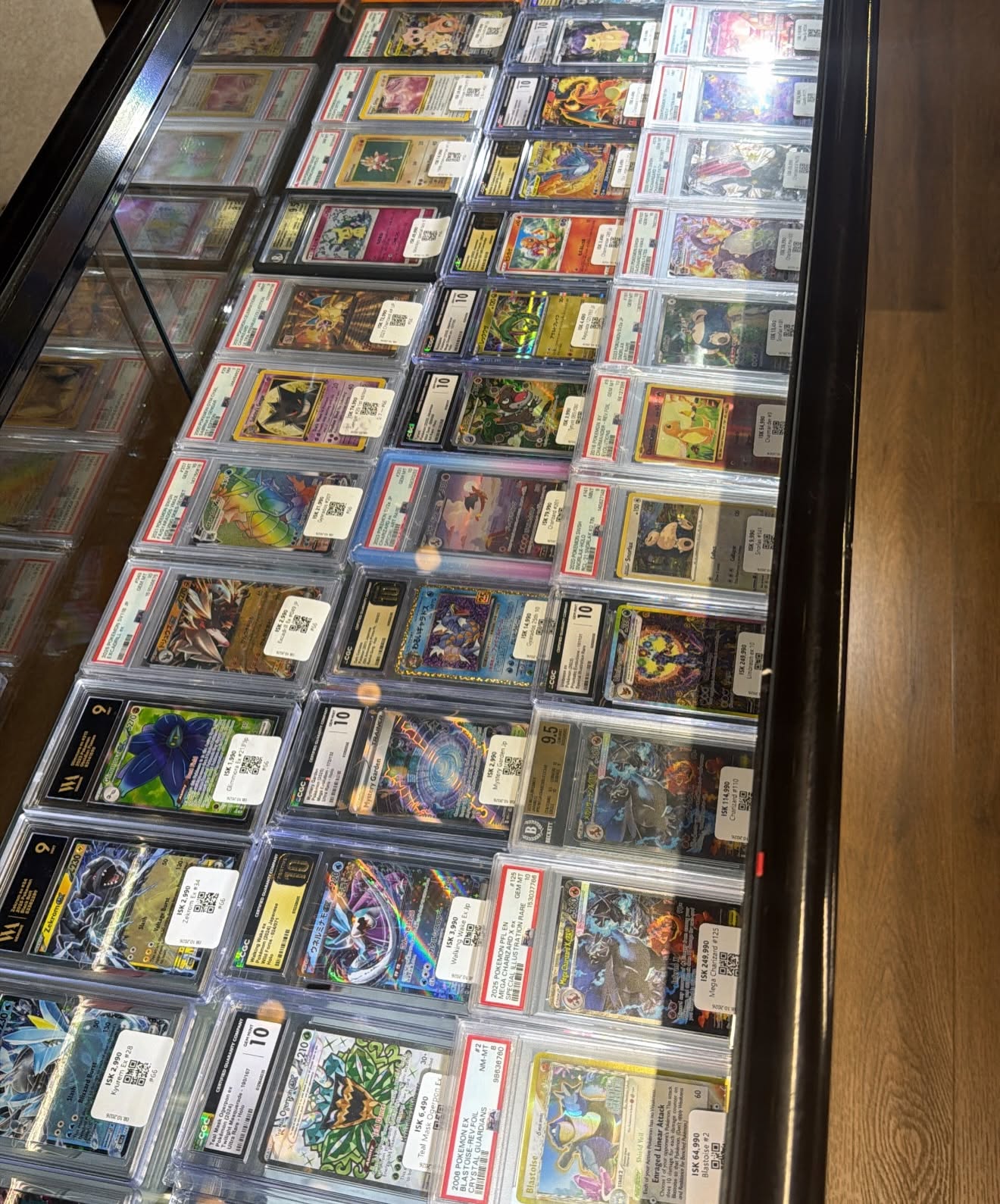 Pokémon-safnspil í hlífðarhylkjum í glerskáp verslunarinnar